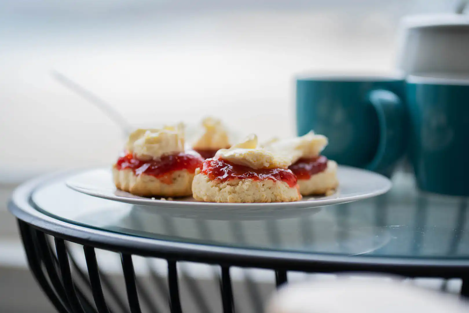 A plate of Cornish cream teas, with a Cornish recipe, featuring scones, clotted cream, and jam, set on a table for Mother's Day celebration.
