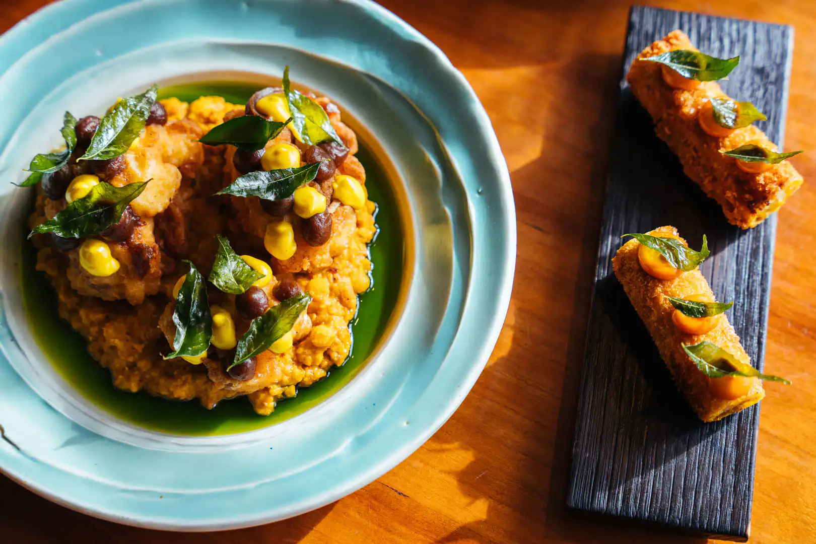 A plate of delicious food accompanied by a side dish, showcasing a meal from Kota Restaurant in Porthleven, Cornwall, a great place to eat out in Cornwall.