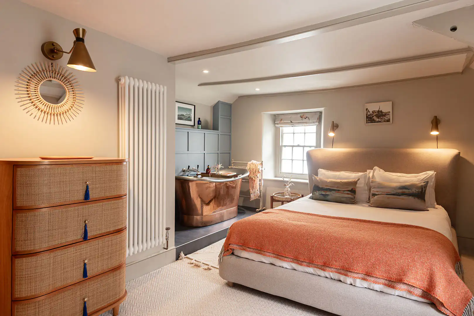The Shambles main bedroom showcases a bed, dresser, and a luxurious bathtub for comfort and style, all great ideas for a holiday cottage.